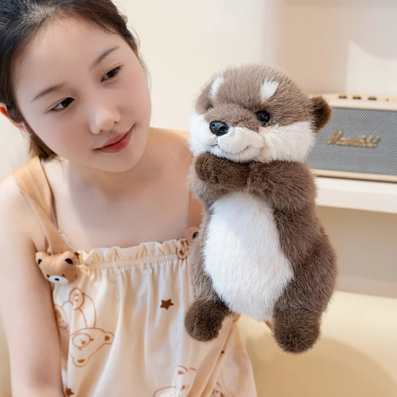 A young woman is holding a brown and white magnetic otter plush toy.