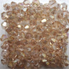 A cluster of faceted rose-colored glass bicone beads for jewelry making.