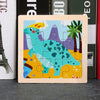 A wooden jigsaw puzzle featuring a teal dinosaur against a purple mountain landscape and palm trees.