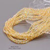 A close-up of yellow-gold faceted crystal rondelle beads strung together for jewelry making.