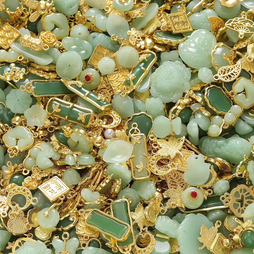 A close-up of green imitation jade charms and beads mixed with gold-colored jewelry findings.
