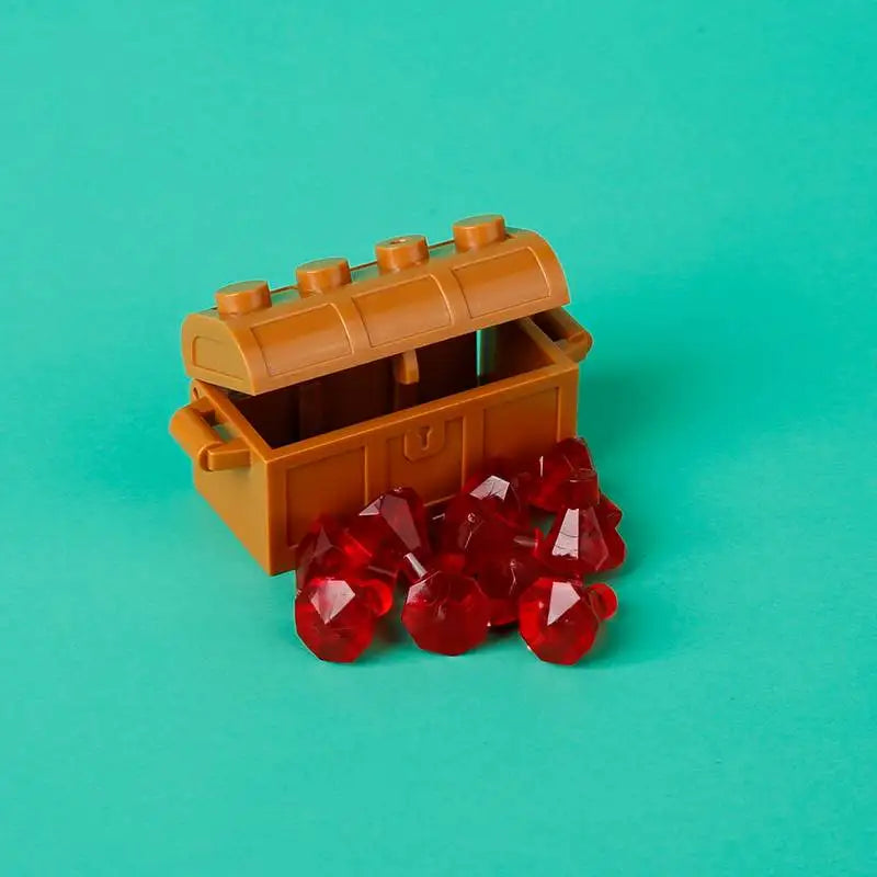 A wooden building block treasure chest set with gold and silver coins resting on a teal background.