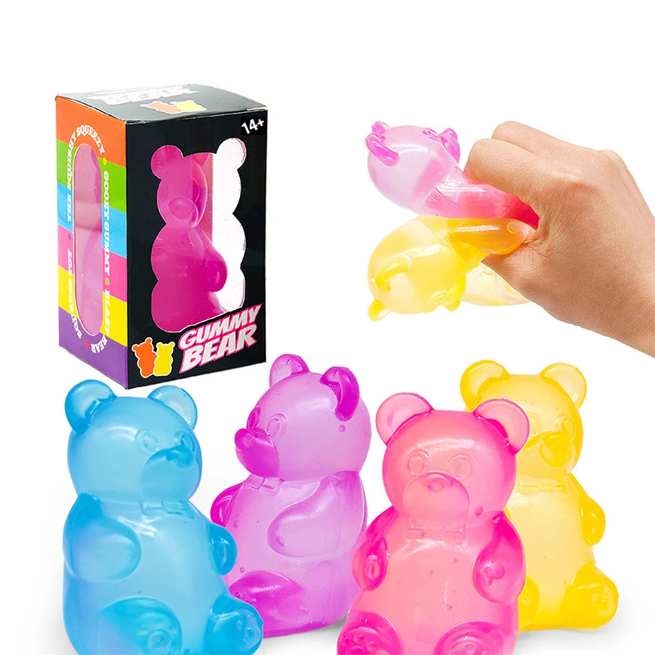 A hand holds a pink gummy bear toy alongside several translucent plastic gummy bear figures.