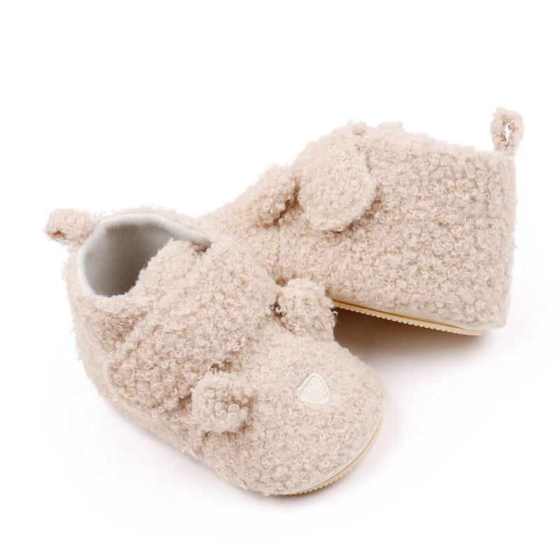A pair of light beige fuzzy bear design baby prewalker shoes with a soft anti-slip sole.