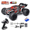 A black and red brushless 4WD monster truck RC car with large tires and accessories.