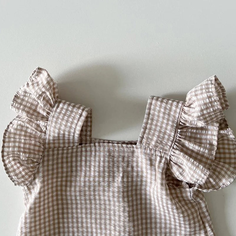 A light beige gingham ruffle top and shorts set for a baby girl summer outfit.