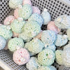 A white basket filled with various pastel-colored squishy stress relief balls and fidget toys.