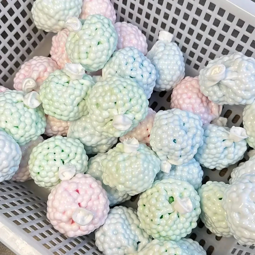 A white basket filled with various pastel-colored squishy stress relief balls and fidget toys.