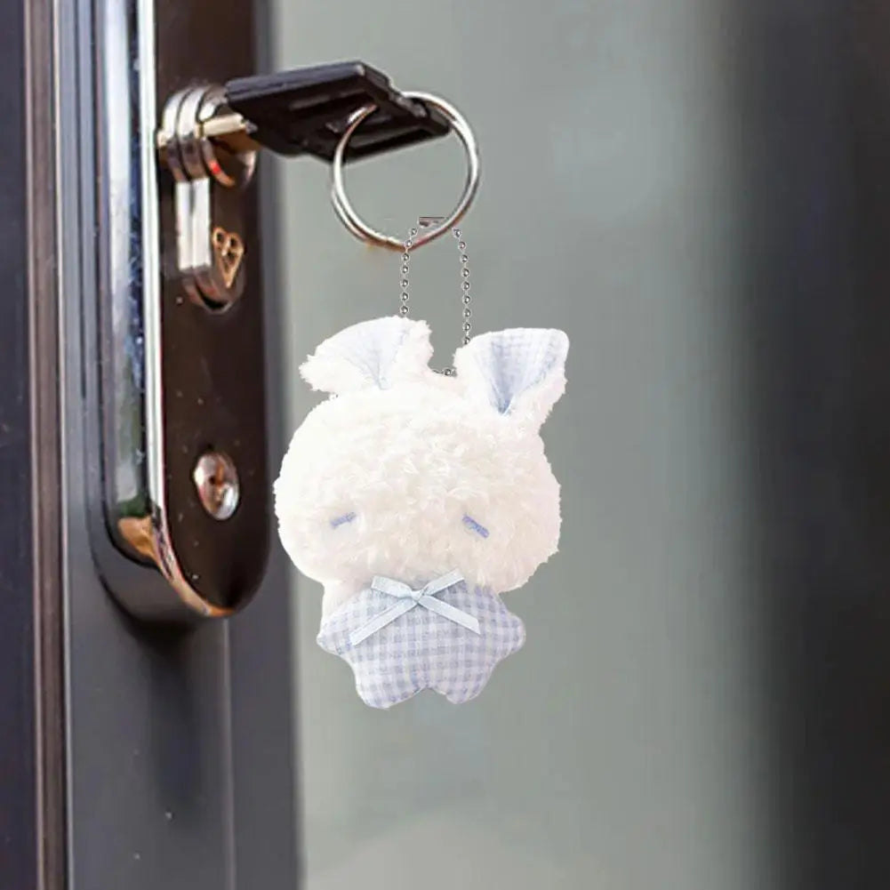 A white fluffy bunny plush toy with blue accents and a checkered bow is attached to a metal keychain.