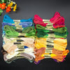 A collection of vibrant organic cotton embroidery floss in various colors laid out on a dark surface.