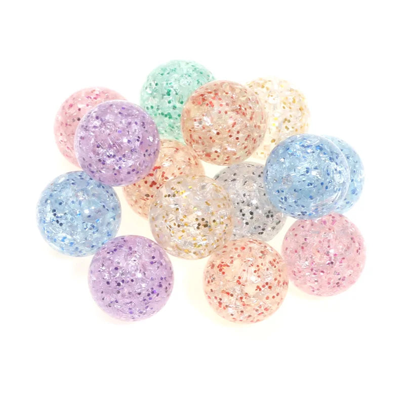 A collection of round glitter acrylic beads in various shades including purple, pink, blue, and gold.