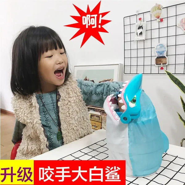 A child is playing with a blue shark toy, which is part of a prank board game set.