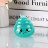 A bright teal glitter squishy stress ball shaped like a smiling face resting on a white surface.