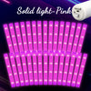 A row of pink LED light foam glow sticks illuminating a dark background.