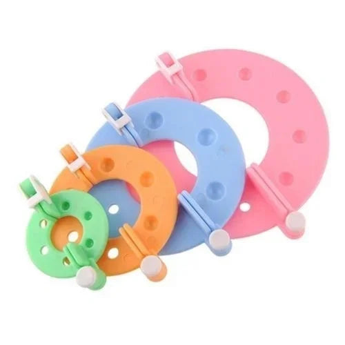 An 8-piece pom pom maker kit with pink, blue, and green plastic tools for DIY crafting.