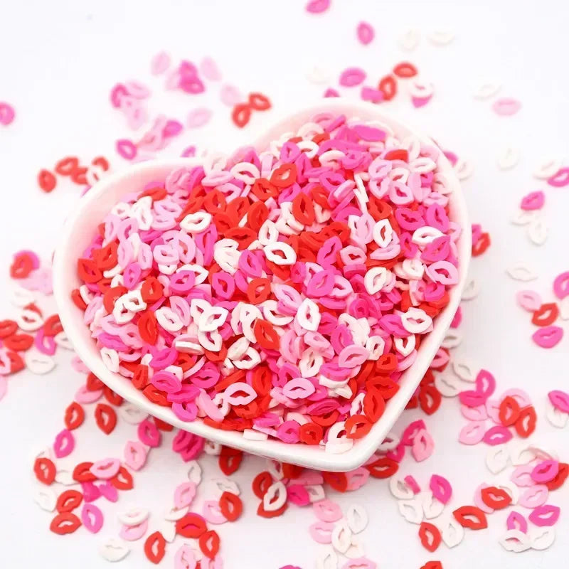A pink and red polymer clay sprinkle mix is shown in a white dish with loose sprinkles scattered around.
