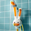 A white rabbit-shaped electric bath shower toy spraying water in a tiled bathroom setting.