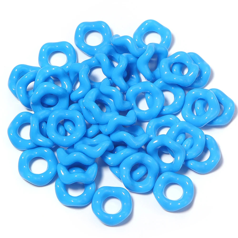 A pile of bright blue acrylic doughnut spacer beads for jewelry making