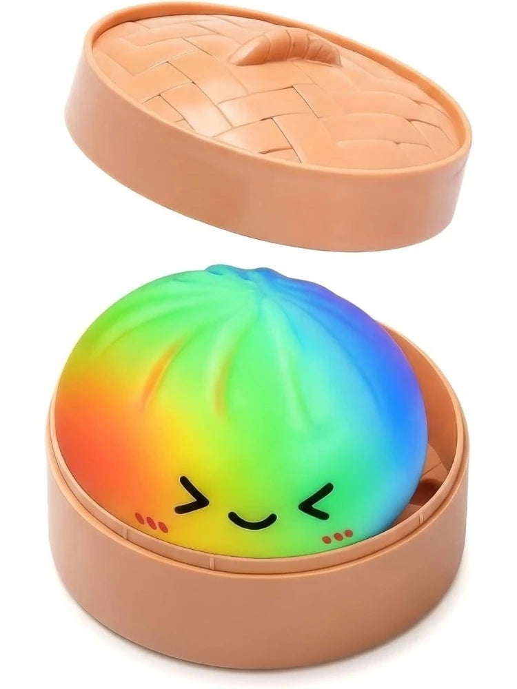 A squishy toy shaped like a dumpling with a rainbow gradient color inside a pink silicone dish.