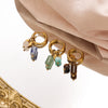 Gold hoop earrings featuring various natural stones including blue and green gems