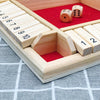 A wooden dice game set with numbered wooden blocks and dice placed on a red felt board.
