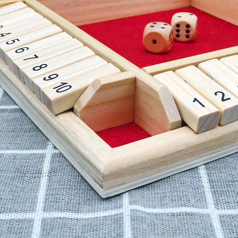 A wooden dice game set with numbered wooden blocks and dice placed on a red felt board.