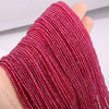 A hand is holding a strand of pink faceted natural stone beads for DIY jewelry making.