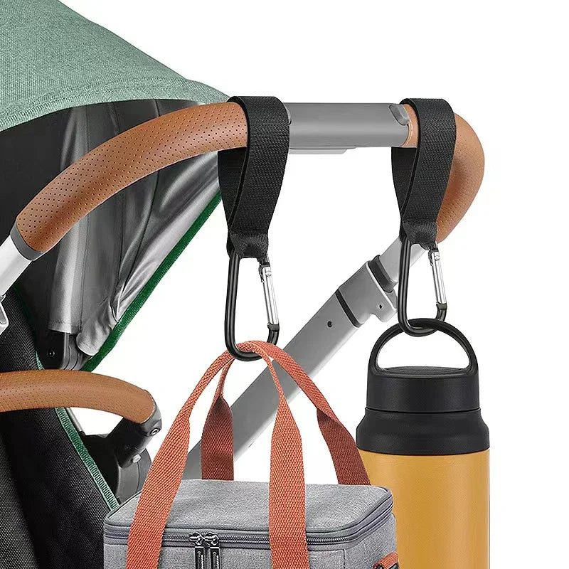Aluminum alloy stroller hooks with nylon straps hanging from a stroller bar