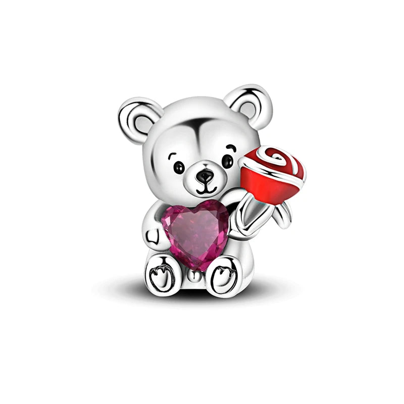 A silver teddy bear charm holding a red and white striped heart bead with a pink zircon.