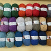 A collection of soft milk cotton yarn in various colors and textures laid out for knitting and crochet.