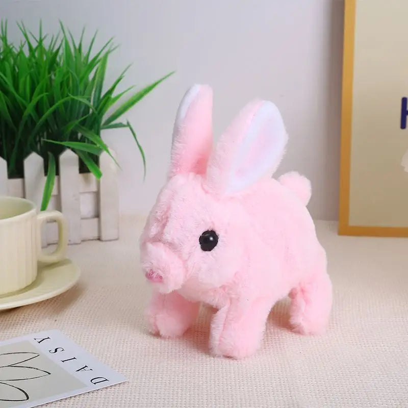 A pink plush toy of a rabbit standing on a white surface.
