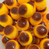A close-up of squishy pudding stress balls in yellow and brown colors.