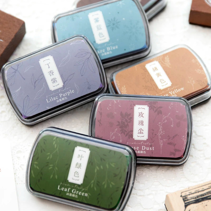A collection of vintage craft oil-based ink pads in various colors including Lilac Purple, Azure Blue, and Leaf Green.