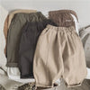 A set of beige and gray loose wide-leg harem pants for boys displayed on a light background.