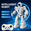 A white intelligent robot toy standing next to a white remote control gamepad.