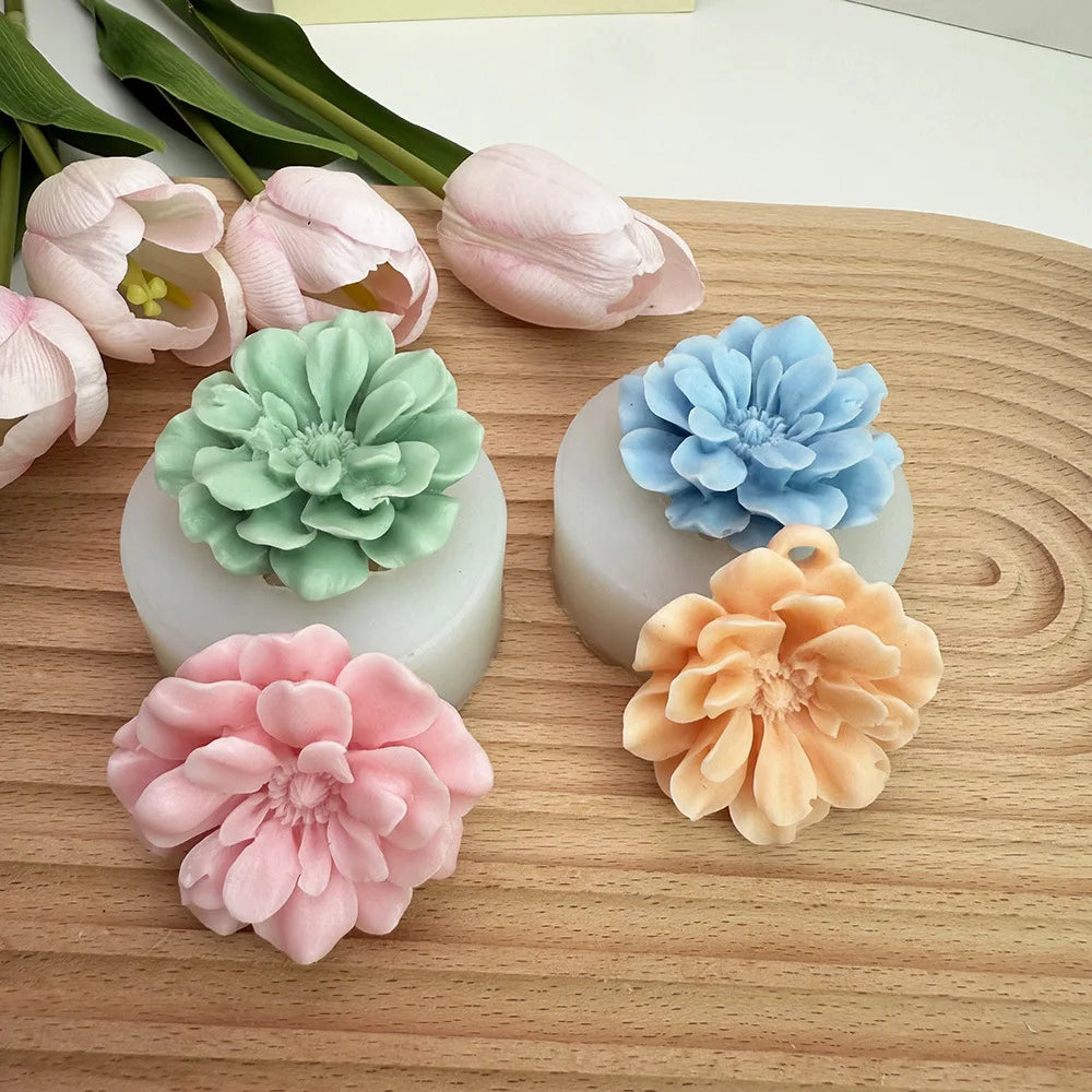 A collection of pink, peach, and blue silicone 3D carnation flower molds for candle making and crafting.