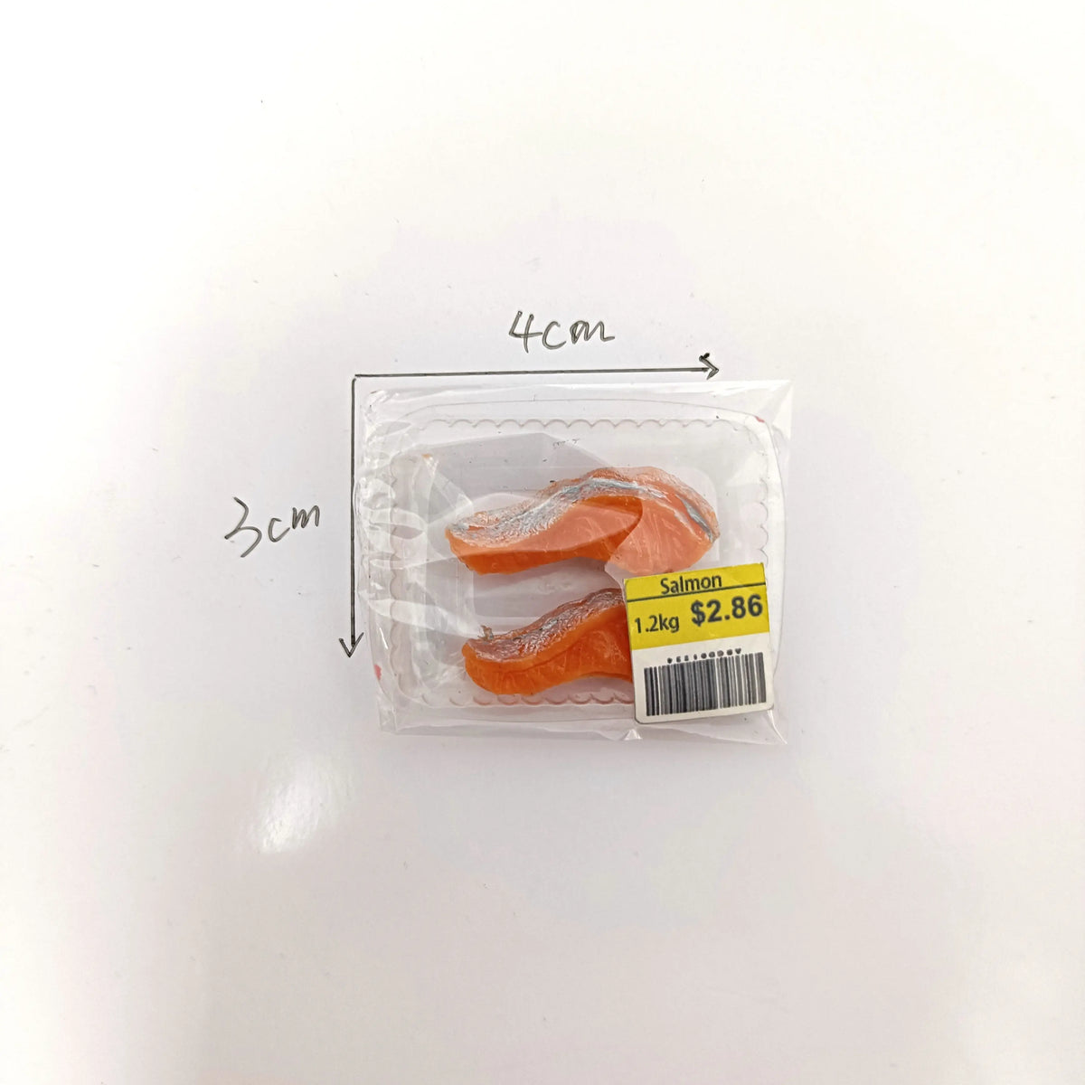 A clear plastic package containing realistic salmon and steak food rolls.