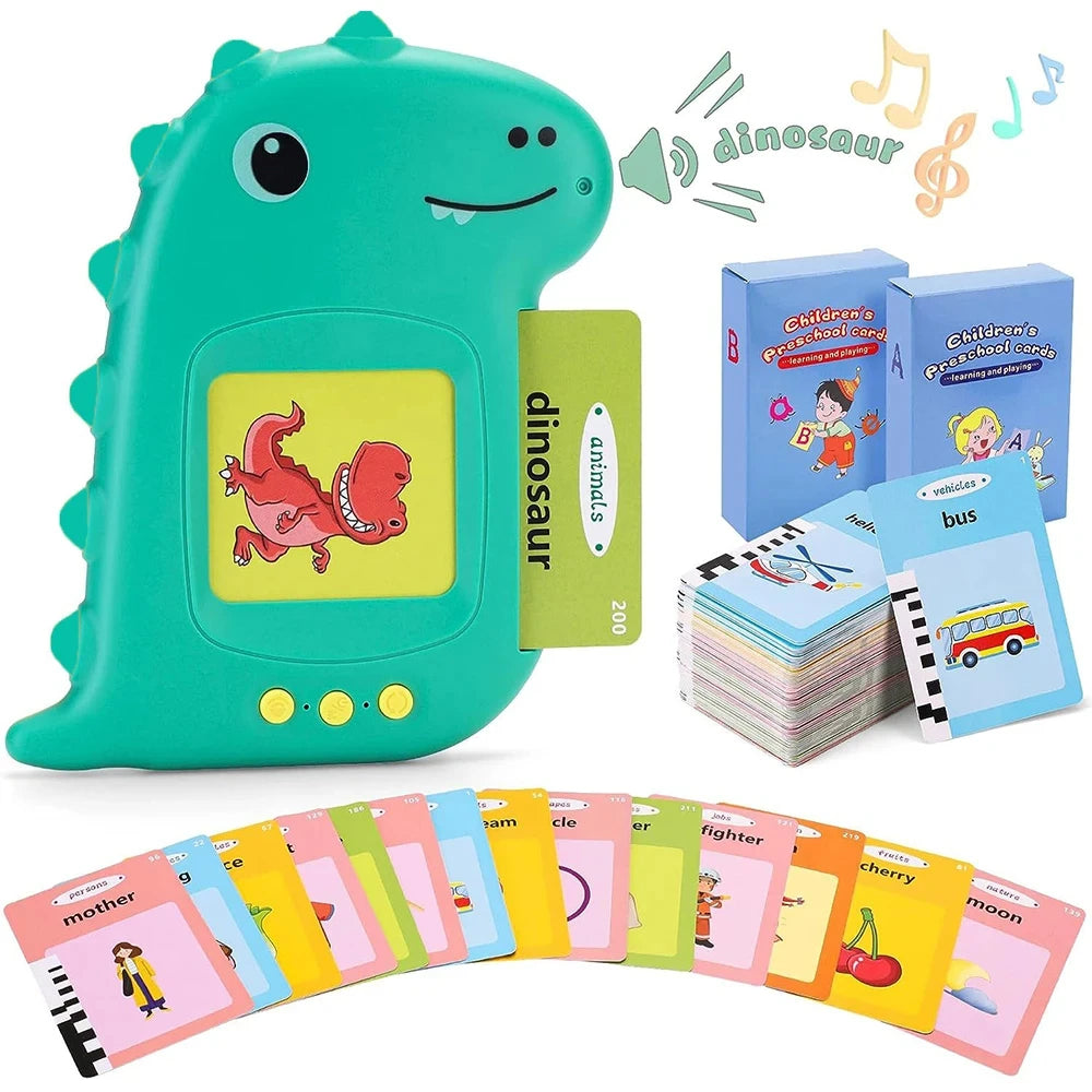A green dinosaur-shaped learning machine with flash cards and a bus toy, alongside a set of colorful flash cards.