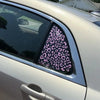Close-up of a car window featuring a leopard print decal on the glass.