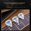 Close-up of several white Alices guitar picks resting on a wooden guitar fretboard.