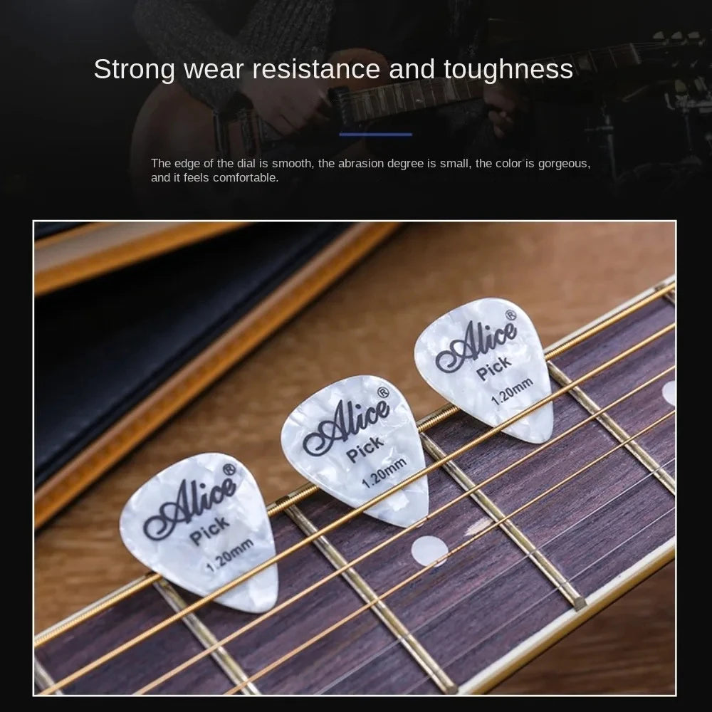 Close-up of several white Alices guitar picks resting on a wooden guitar fretboard.
