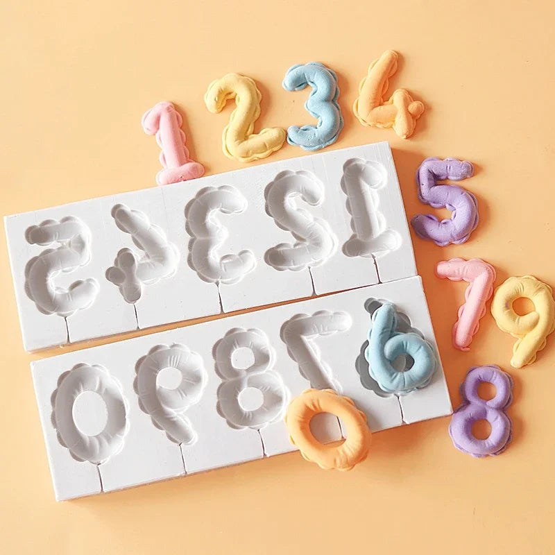 A silicone mold set featuring numbers 1 through 8 in pastel colors like pink, yellow, and blue on a white tray.