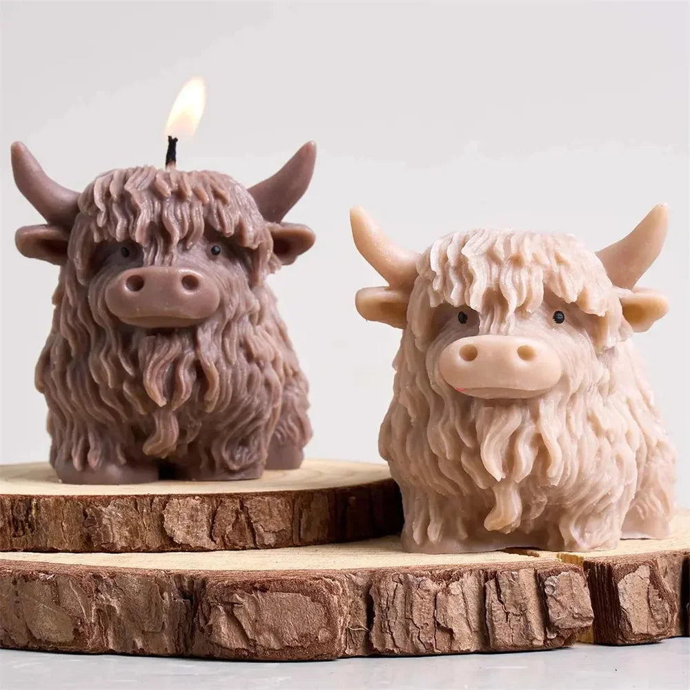 A realistic silicone mold of a Highland cow head used for making candles, soap, and crafts, displayed on a wooden slice.
