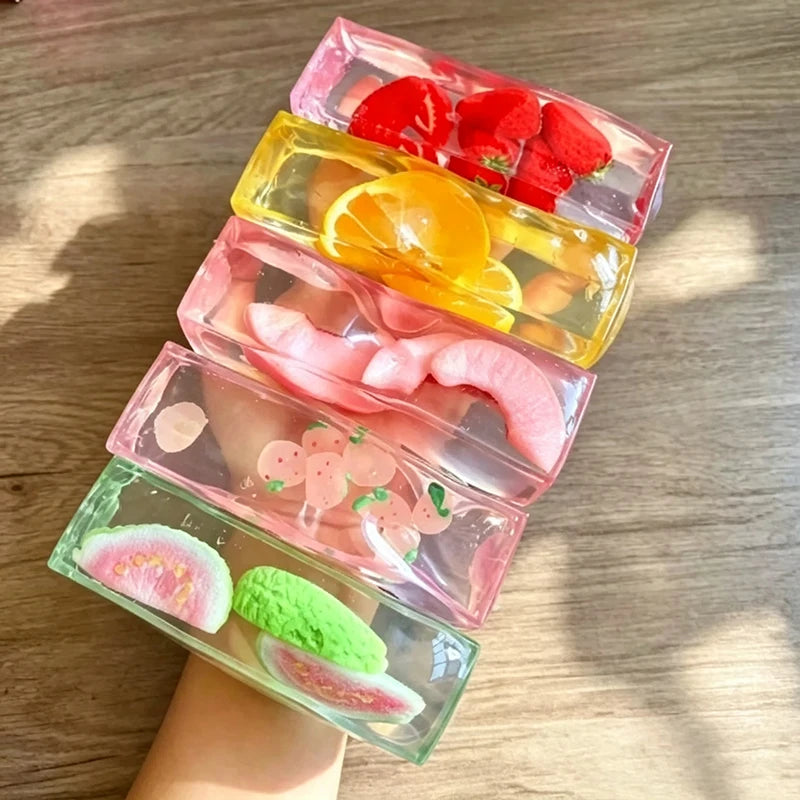 A stack of pink and yellow fruit-themed squishy stress relief toys shaped like ice cubes.