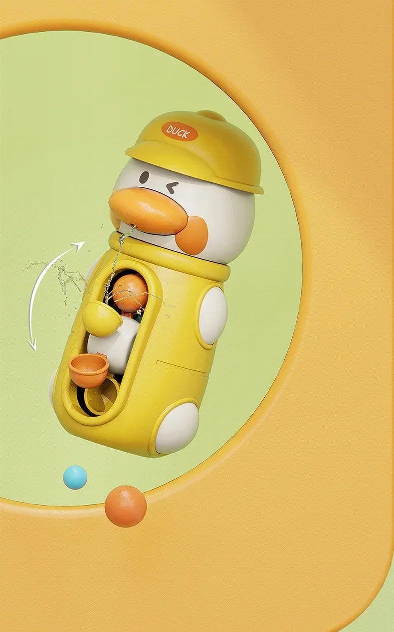A yellow duck-shaped bath toy with a helmet is shown, featuring suction cup waterwheels and various colored balls.