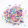 A bowl filled with colorful polymer clay sprinkles in various star shapes scattered on a white background.