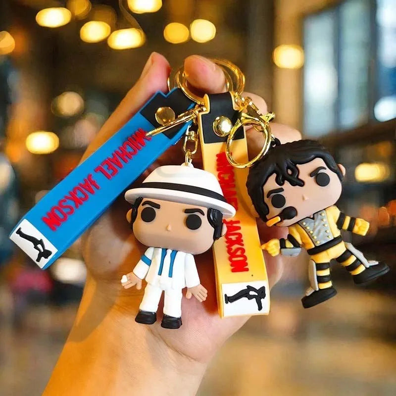 A hand holds a Michael Jackson Music Icon keychain with a metal buckle and a yellow tag.