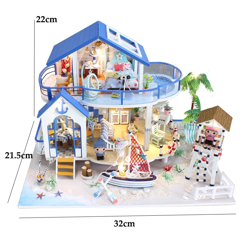 A miniature dollhouse kit of a seaside beach house with a balcony and interior decor on a white base.