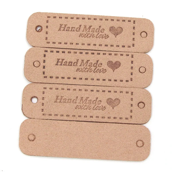 A stack of four light brown leather-style handmade with love tags for crafts and sewing.