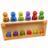 A set of nine colorful, striped balls in various colors arranged in a wooden tray for matching activities.